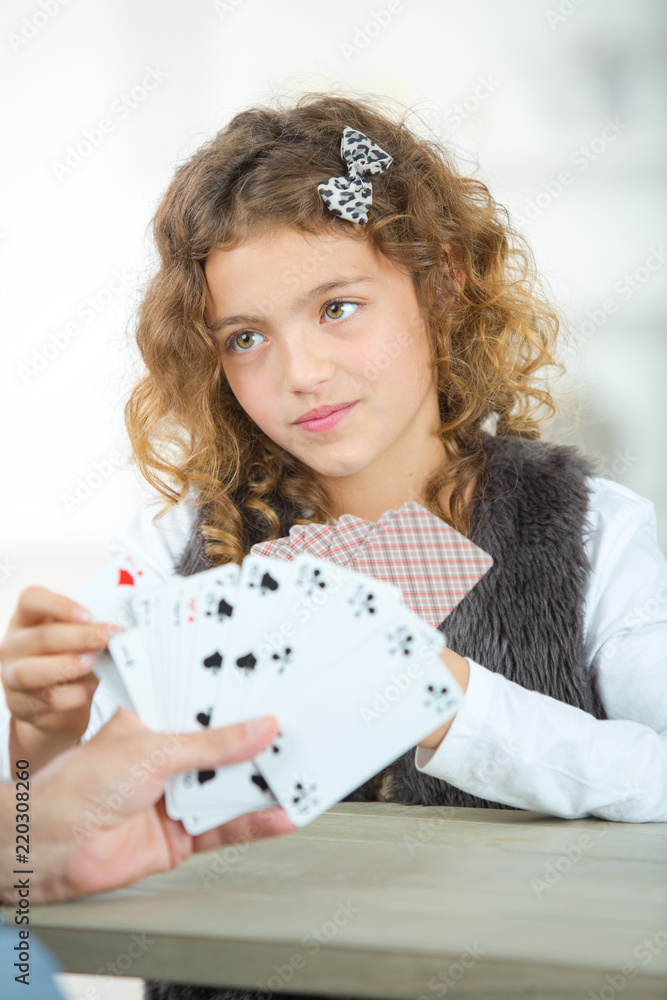 portrait of smiling little girl playing cards portrait of smiling little girl playing cards