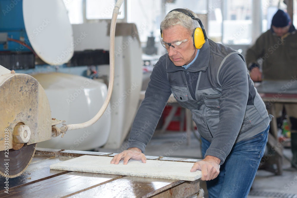 worker doing his job on big machine for profile cutting worker doing his job on big machine for profile cutting