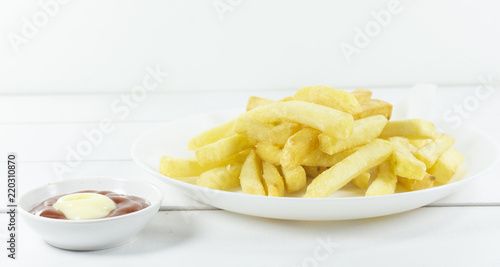 French Fries and tomato sauce in a white dish on a wood floor table,Front view Copy space.