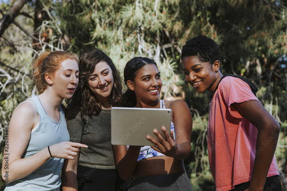 Obraz premium Group of active women looking at a digital tablet