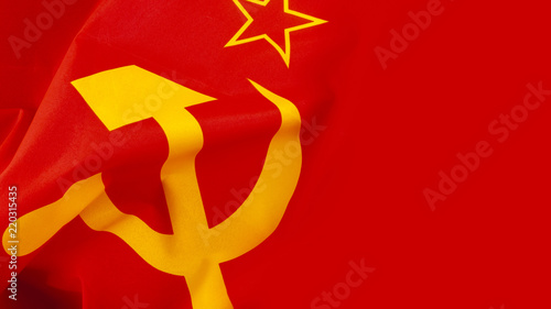 Communism and Marxism concept with close up on the hammer and sickle from the flag of the old Union of Soviet Socialist Republics (USSR or Soviet Union) with a wave and copy space photo