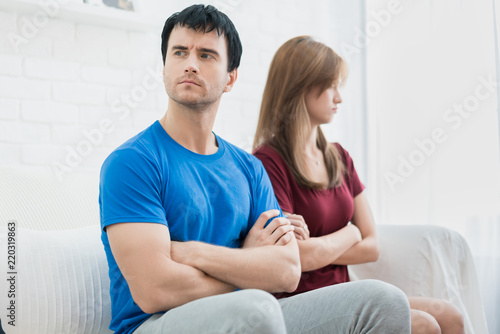 Unhappy couple not talking after an argument in sofa at home. People, relationship difficulties and family concept.