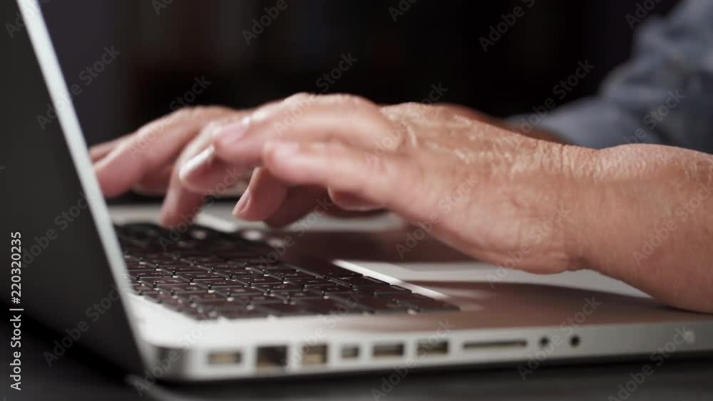 Grandmother works behind laptop, typing on keyboard with her old hands with wrinkles. Modern old pensioner working from home. Close up view of elderly woman's hands. 4k Grandmother works behind laptop, typing on keyboard with her old hands with wrinkles. Modern old pensioner working from home. Close up view of elderly woman's hands. 4k
