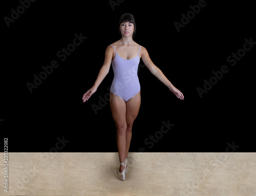Young Ballerina Dancer in a Lilac Leotard in a Studio on a Black Backdrop