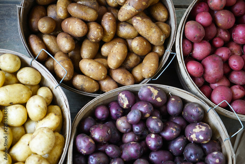 Fotografija Multicolored Potatoes in Baskets at Market