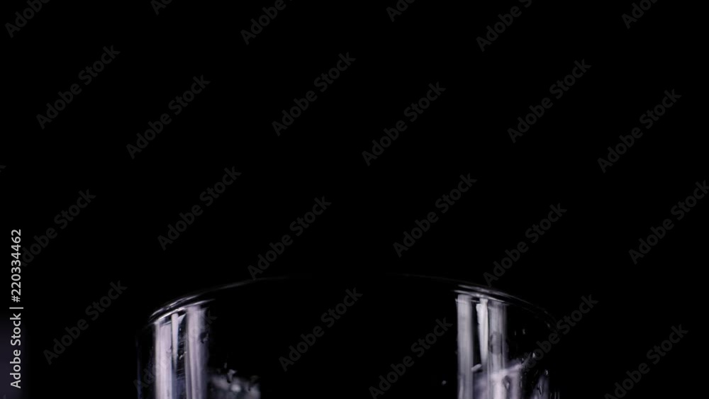 Making a Mojito cocktail; Close-up of ice chunks added to a highball glass; isolated on black. Making a Mojito cocktail; Close-up of ice chunks added to a highball glass; isolated on black.