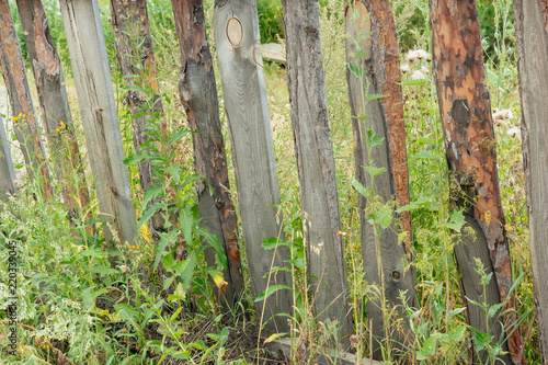 Old weathered fence of wooden boards of different sizes