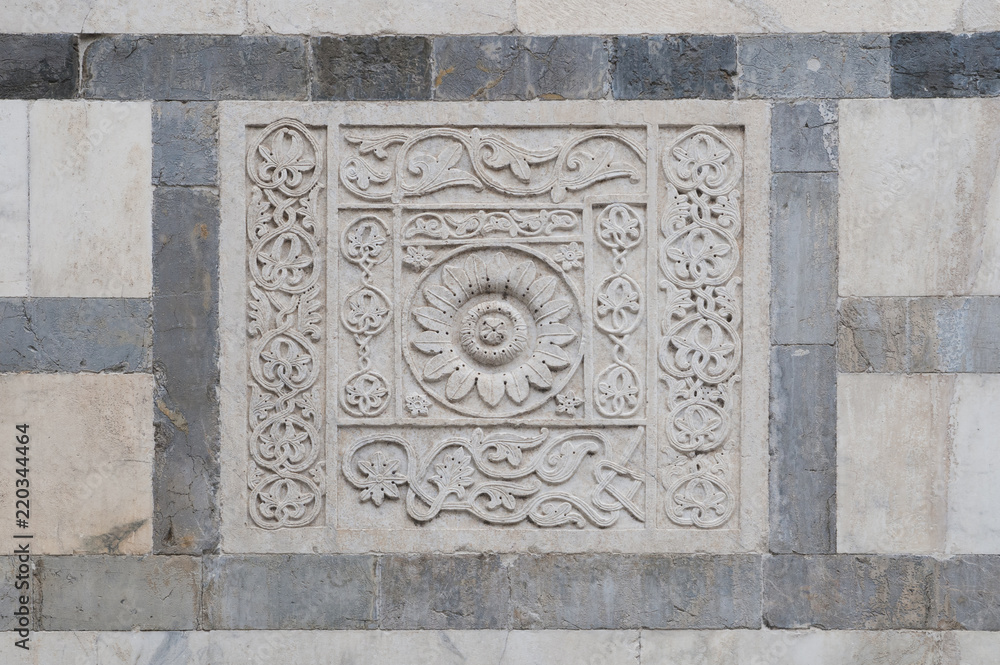 Bas-relief in white marble on the facade of the Carrara cathedral Bas-relief in white marble on the facade of the Carrara cathedral