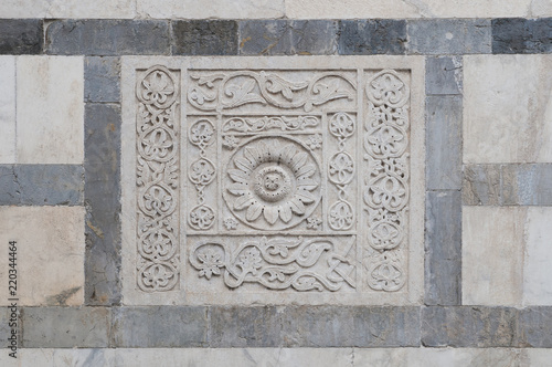 Bas-relief in white marble on the facade of the Carrara cathedral