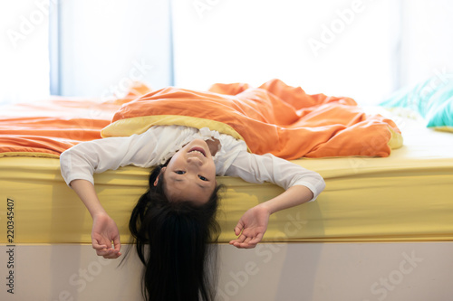Portrait of little girl under blanket in the bedroom at home,smile happily,child and home concept