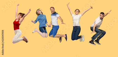 Freedom in moving. Mid-air shot of pretty happy young man and women jumping and gesturing against studio background. Runnin girl in motion or movement. Human emotions and facial expressions concept