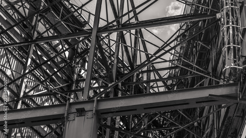 Metal structure of a huge road billboard, rusted metal and scraped paint in the scene. Black and white picture. Metal structure of a huge road billboard, rusted metal and scraped paint in the scene. Black and white picture.