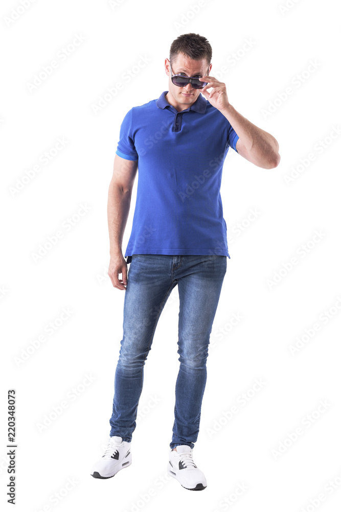 Young man holding sunglasses with over the glasses look at camera. Full body isolated on white background. Young man holding sunglasses with over the glasses look at camera. Full body isolated on white background.