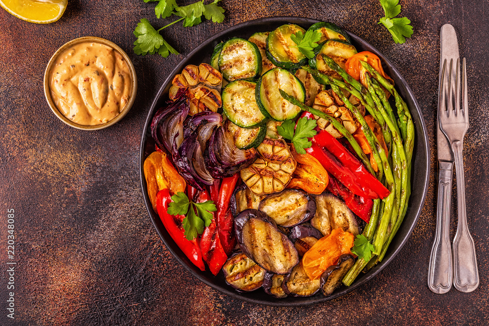 Grilled vegetables on a plate with sauce.