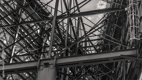 Metal structure of a huge road billboard, rusted metal and scraped paint in the scene. Black and white picture.