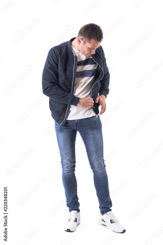 Young adult man in bomber jacket searching for something lost in the pocket. Full body isolated on white background. Young adult man in bomber jacket searching for something lost in the pocket. Full body isolated on white background.