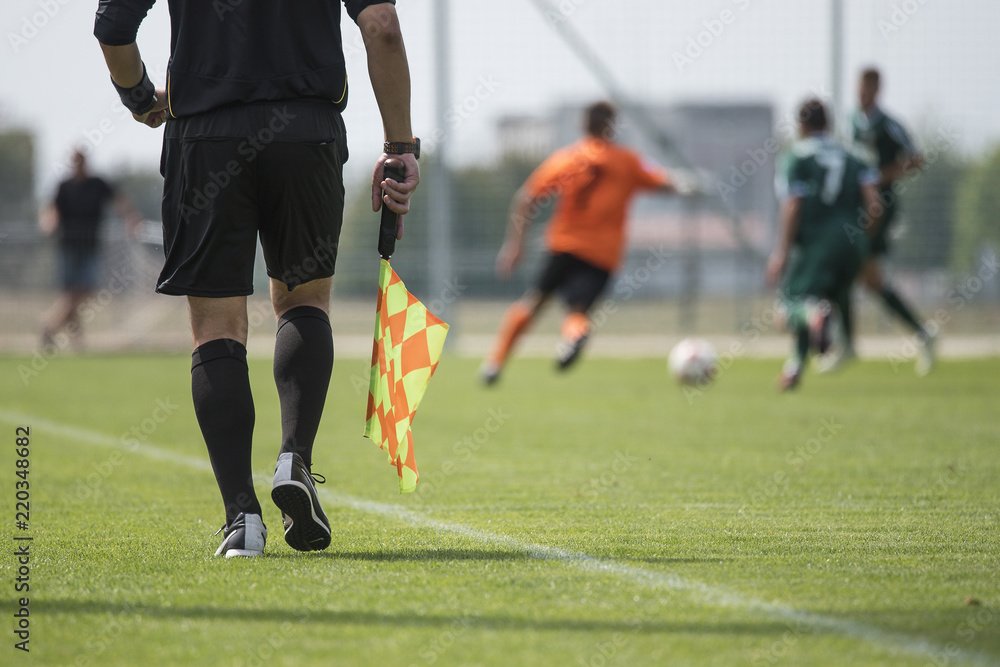 Fototapeta premium Legs of assistant of football referee with the flag