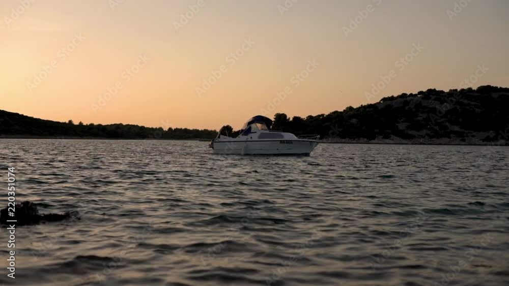 Boat sailing in bay during sunset in slow motion Boat sailing in bay during sunset in slow motion