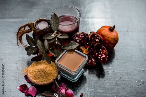 Herbal and organic face pack of pomegrante with some raw pomegranate juice and fuller's earth or mulpani mitti,and rose water on wooden surface to have a health bright acne and pimple free skin. photo