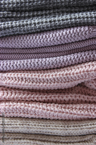 a stack of knitted sweaters of different colors close-up. Background