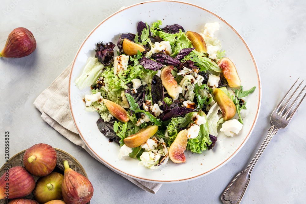 Salad with figs on a gray stone background