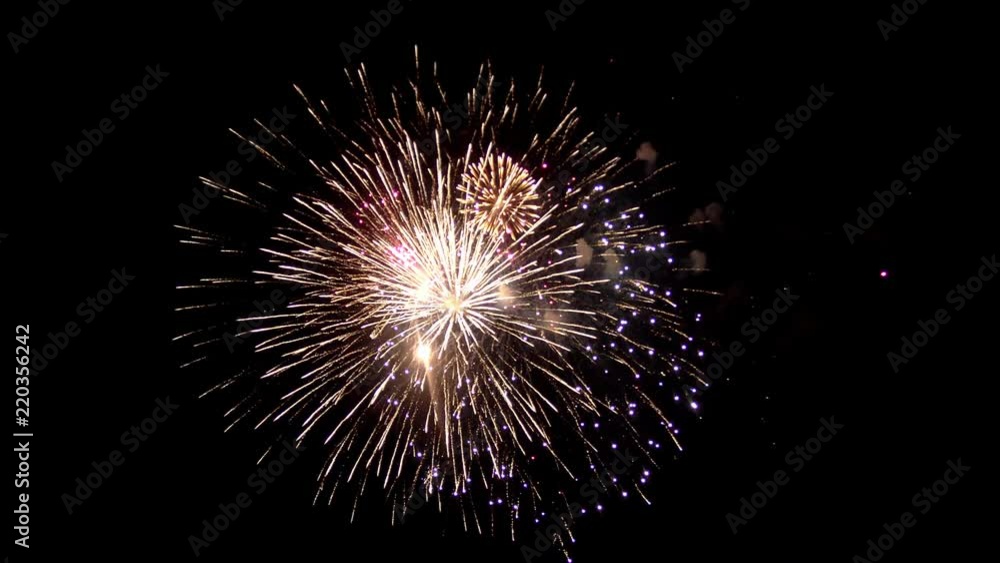 A beautiful dark sky is lit by flashes of festive fireworks. A rich crimson color is visible all over the sky. Sparks in a misty cloud of bright red color. A beautiful dark sky is lit by flashes of festive fireworks. A rich crimson color is visible all over the sky. Sparks in a misty cloud of bright red color.