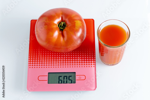 Huge tomato and a glass of tomato juice photo