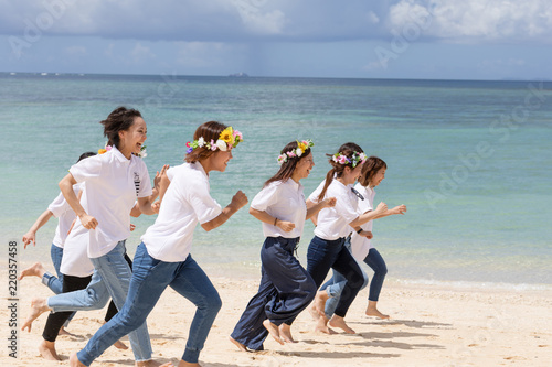 沖縄のビーチを走る女性たち