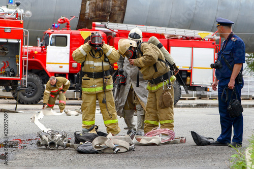 Exercises of rescuers at a chemical plant to save the victim. Rescuers change their outfit after training.