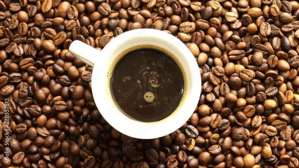 Cup On the Rotation Background of Fried Coffee Greens. Cup On the Rotation Background of Fried Coffee Greens.