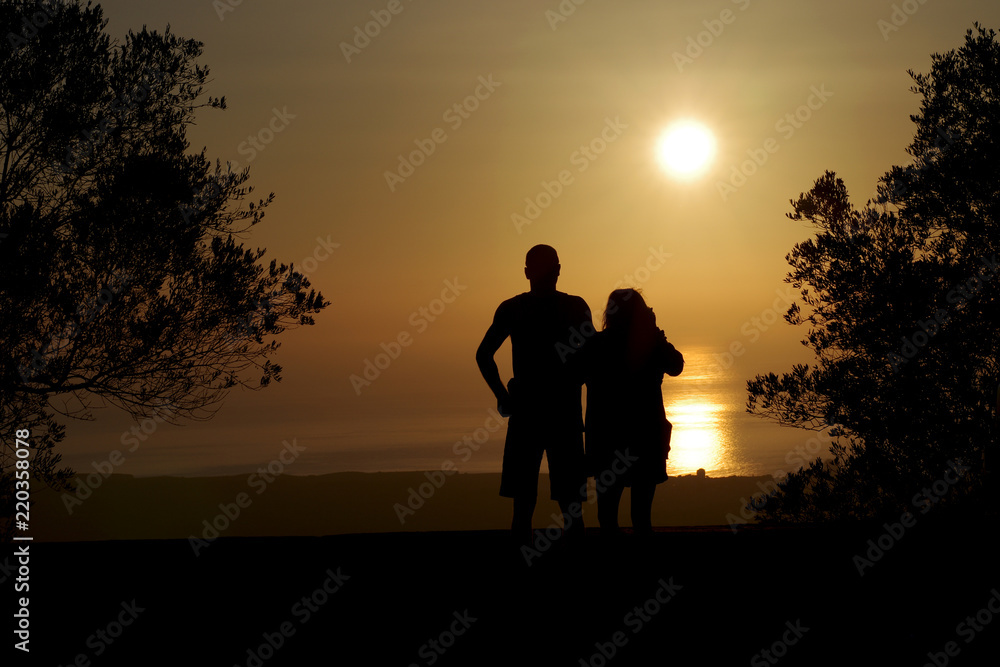 Eine Frau und ein Mann schauen sich den Sonnenaufgang an