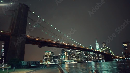 Brooklyn Bridge in New York City illuminated with colorful lights at night