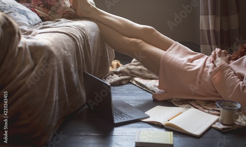 Woman relaxing with feet up in living room photo