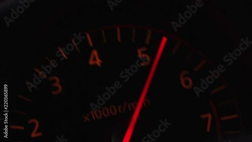 A car's tachometer hitting redline rpm. photo