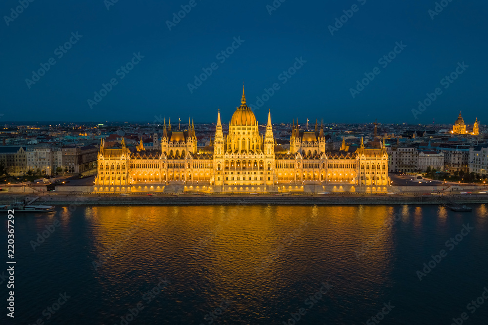 Budapest, Hungary - Aerial blue hour view of the illuminated Parliament of Hungary reflecting on River Danube with St.Stephen's Basilica at background