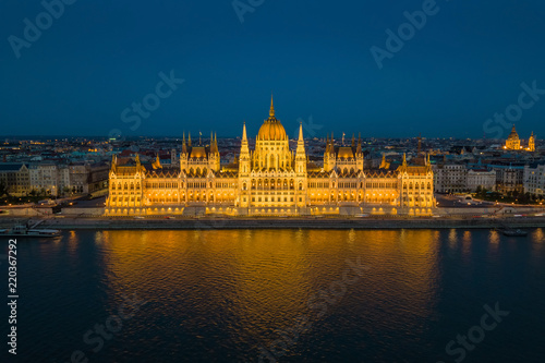 Budapest, Hungary - Aerial blue hour view of the illuminated Parliament of Hungary reflecting on River Danube with St.Stephen's Basilica at background