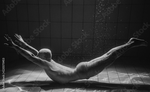 monochome portrait of muscles beard yoga man underwater in the swimming pool photo