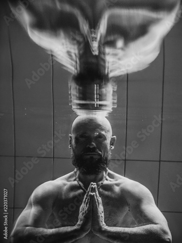 monochome portrait of muscles beard yoga man underwater in the swimming pool photo