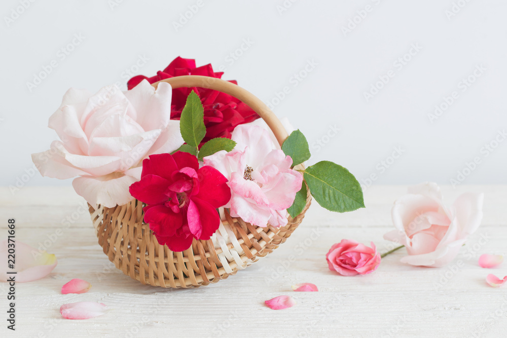 beautiful roses in basket on wooden table beautiful roses in basket on wooden table