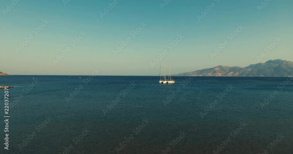 A boat moored at Sunset in middle of the sea. Dodekanisos Islands in Greece, Vacation in Greece, mountain and ocean, Drone aerial shot zoom in A boat moored at Sunset in middle of the sea. Dodekanisos Islands in Greece, Vacation in Greece, mountain and ocean, Drone aerial shot zoom in
