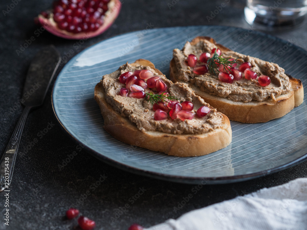 Sandwiches with chicken pate and pomegranate seeds on a blue plate
