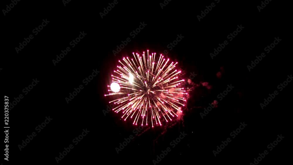 Bright fireworks on the holiday. In the night sky shines a bright fireball crimson. An interesting ball is in the center of fireworks, around small balls of different colors. Bright fireworks on the holiday. In the night sky shines a bright fireball crimson. An interesting ball is in the center of fireworks, around small balls of different colors.