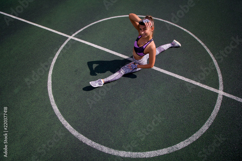 beautiful young athletic girl doing stretching outdoor on the basketball court, sports,  healthy lifestyle concept © dvulikaia