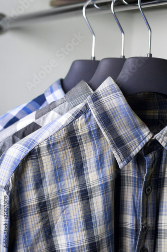 grey blue plaid shirts on hangers