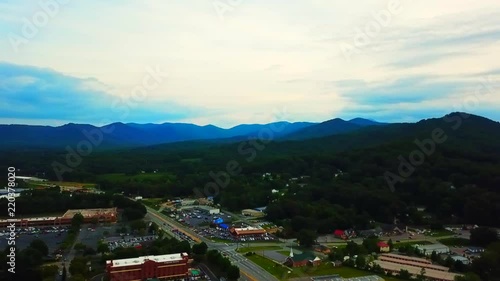 View of the Ashville Town Shopping Mall in the USA, featuring houses, forestry and cars. photo