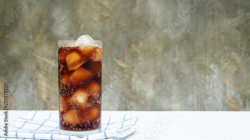 Iced aerated soft drink on a white wooden table.