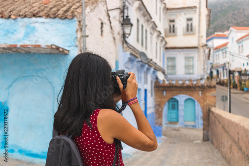 Girl with red shirt photographing the streets of the city