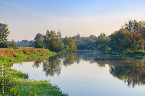 River landscape on a background of blue sky at sunny summer morning