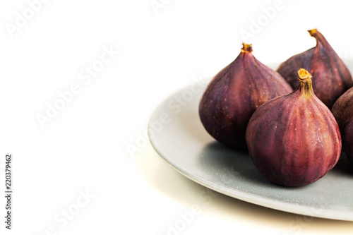 Fresh figs on grey plate isolated on white