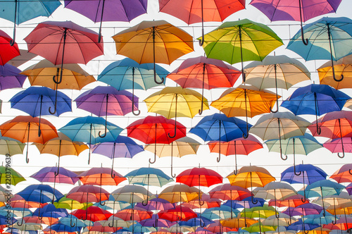 Street decoration with colorful open umbrellas hanging over the alley